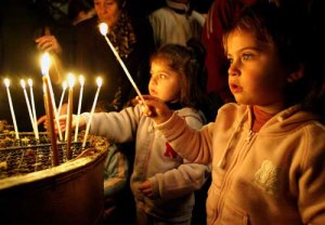 PALESTINIAN CHRISTIANS LIGHT CANDLES IN THE GROTTO UNDER THE CHURCH OF THE NATIVITY IN BETHLEHEM